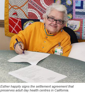 Esther happily signs the settlement agreement that  preserves adult day health centres in California.   